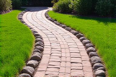 Installed paver walkway surrounded by river rocks